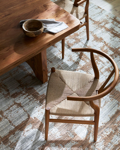 Top-down view of a brown mid-century teak wood modern chair with a seagrass seat.