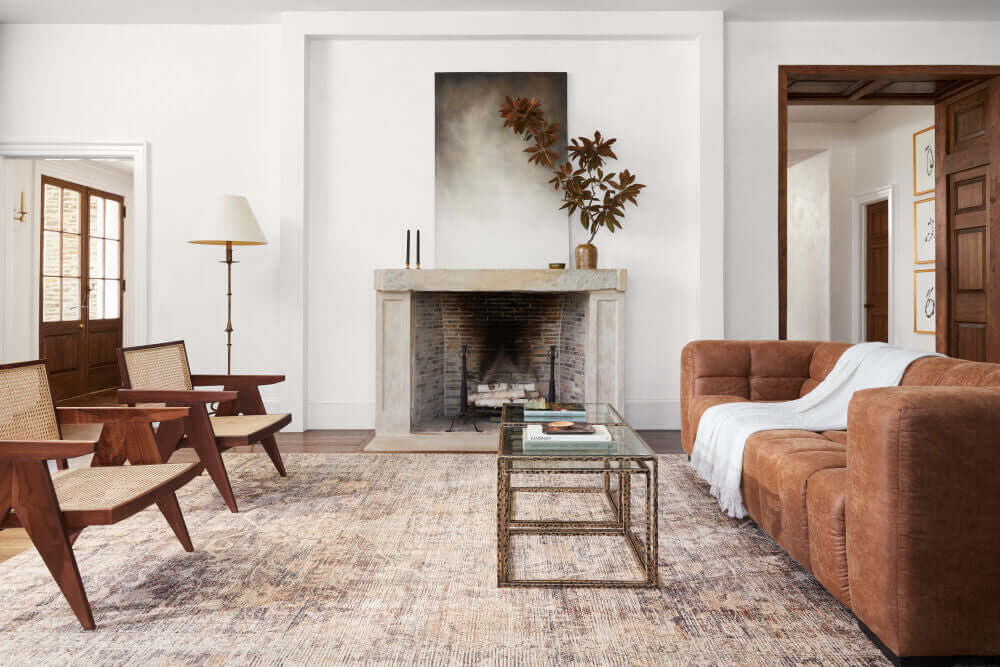 Elegant living room featuring rattan dining arm chairs and a brown sofa.