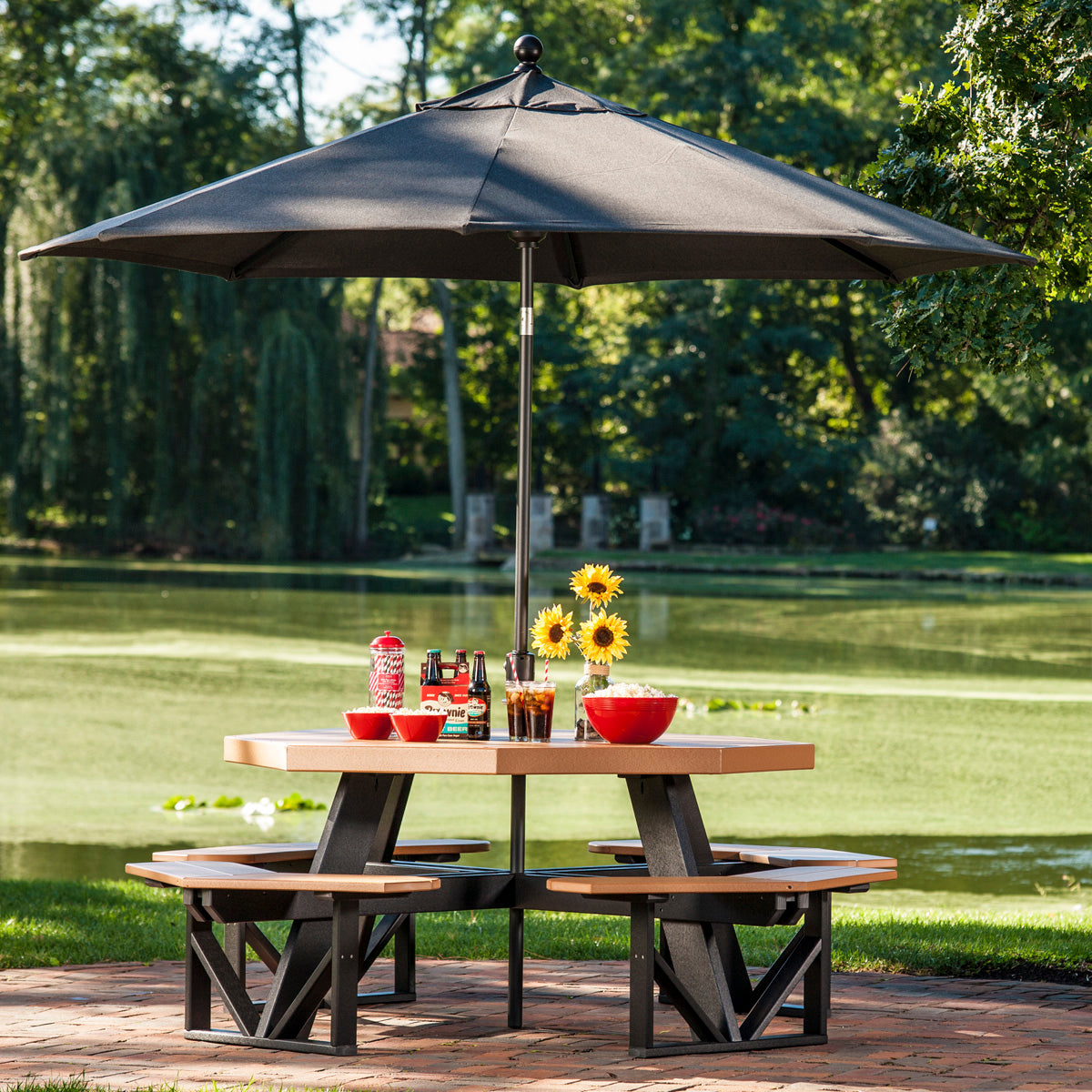 LuxCraft outdoor umbrella in Spectrum Carbon providing shade over a picnic table by a serene lakeside.