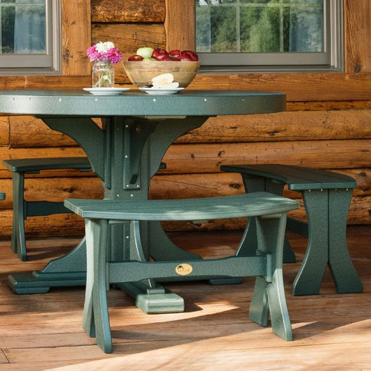 Poly 28" Outdoor Dining Bench in green, placed on a wooden deck near a log cabin.