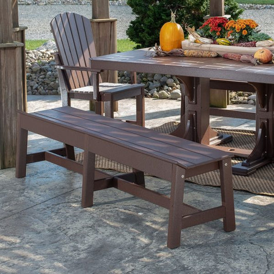 LuxCraft 72-inch Cafe Dining Bench in Antique Mahogany set up in a lush garden for a picturesque outdoor dining experience.