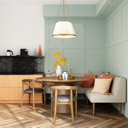 modern gold pendant over cozy dining nook with mint green wall paneling.