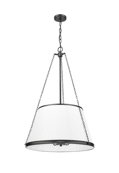 matte black pendant light glowing warmly through pleated white fabric shade.