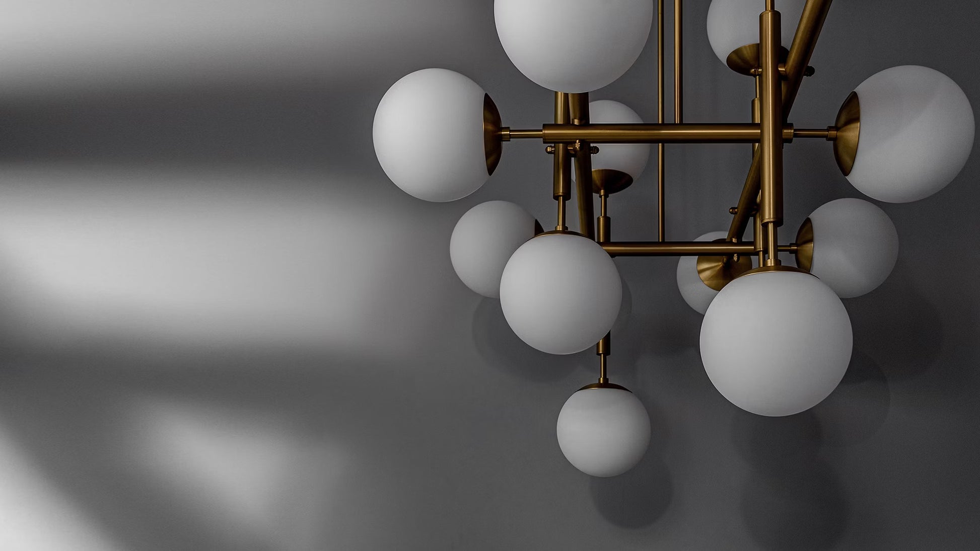 Matte glass globes with brass fittings, casting dramatic shadows in a contemporary setting.