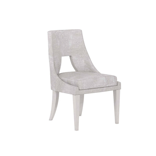  Angle view of grey fabric dining chair with elegant curved back and soft upholstery.