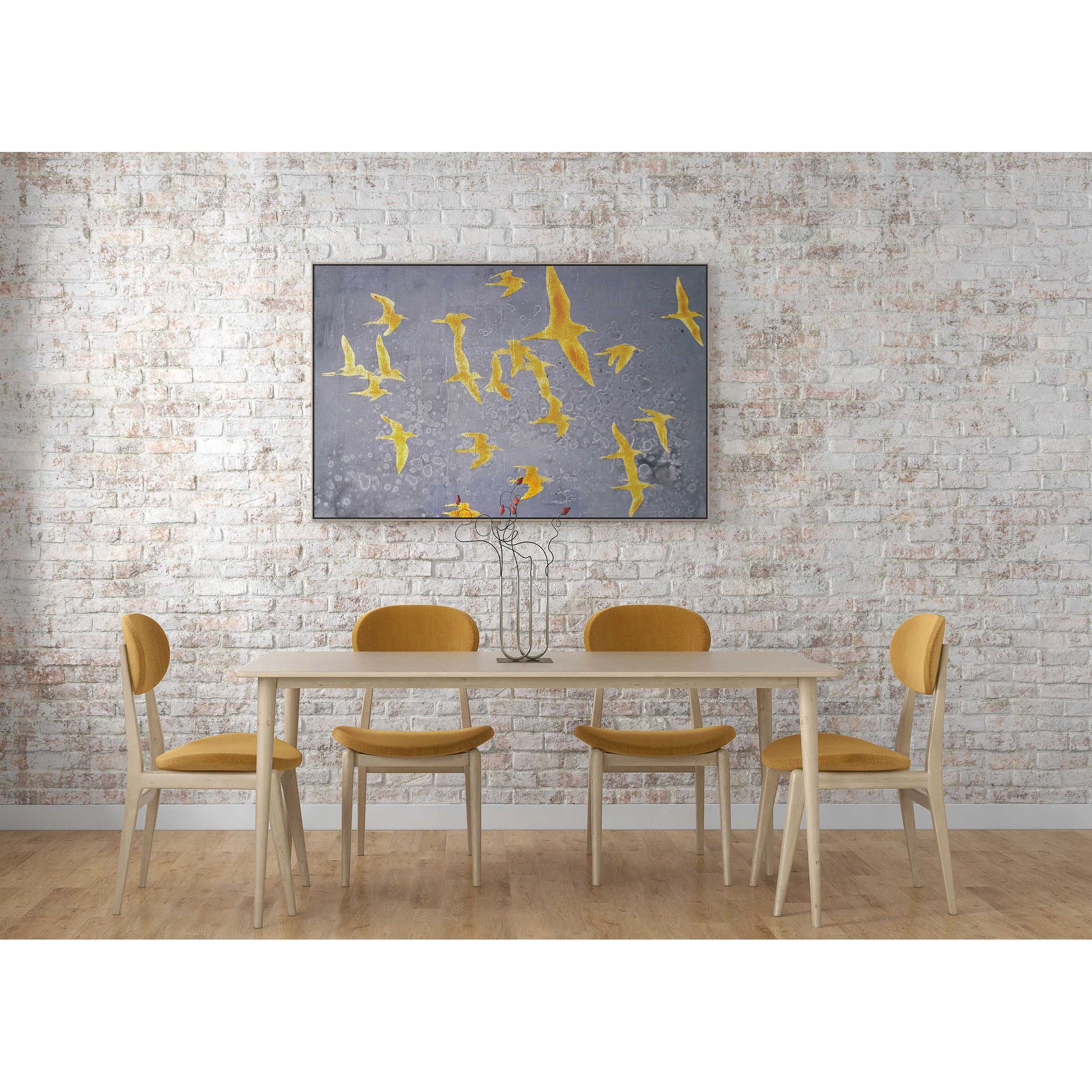 Birds painting displayed above a dining table with mustard-colored chairs.