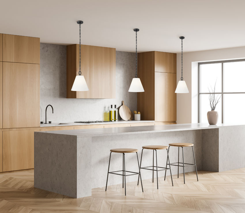 trio of modern black pendant lights above marble island.