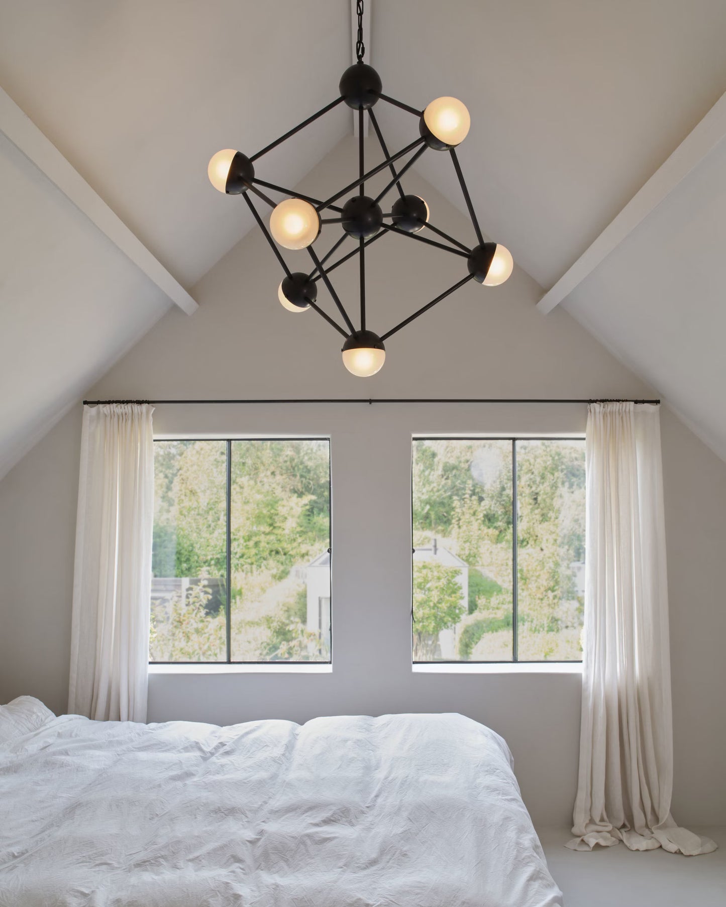 Molecule Chandelier with sandblasted glass globes, adding elegance to a modern bedroom.