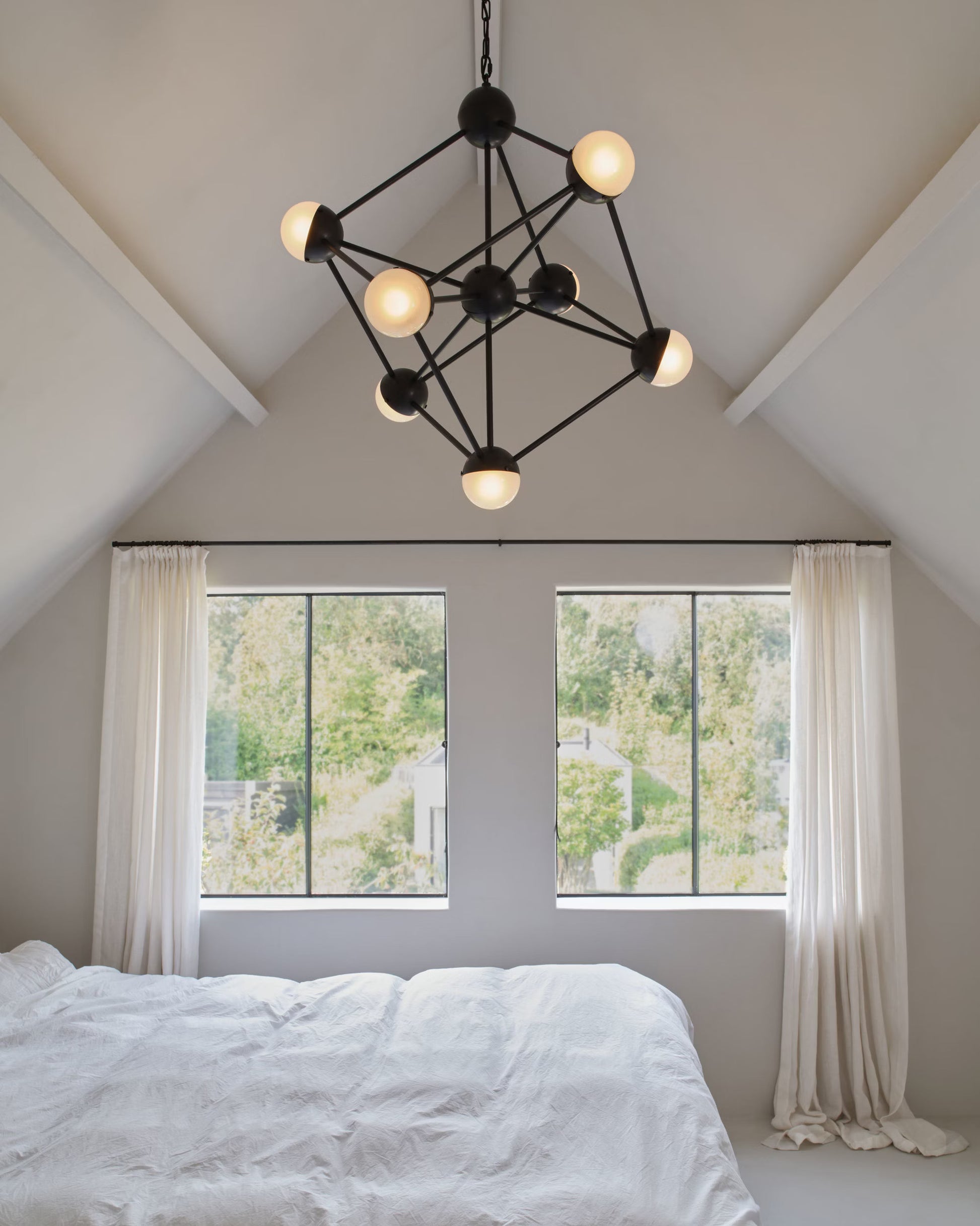 Molecule Chandelier with sandblasted glass globes, adding elegance to a modern bedroom.