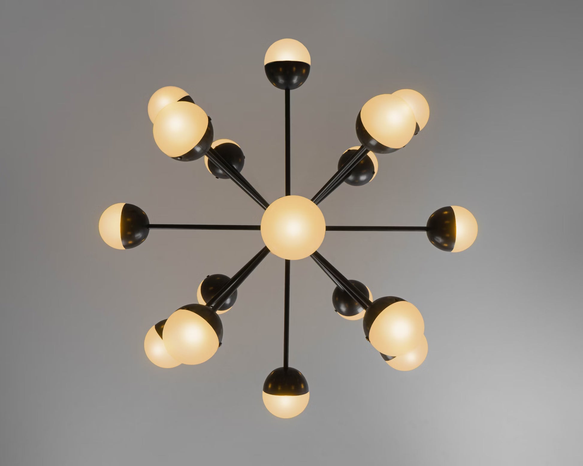 Frosted glass chandelier in black finish, dimmed for ambient lighting.