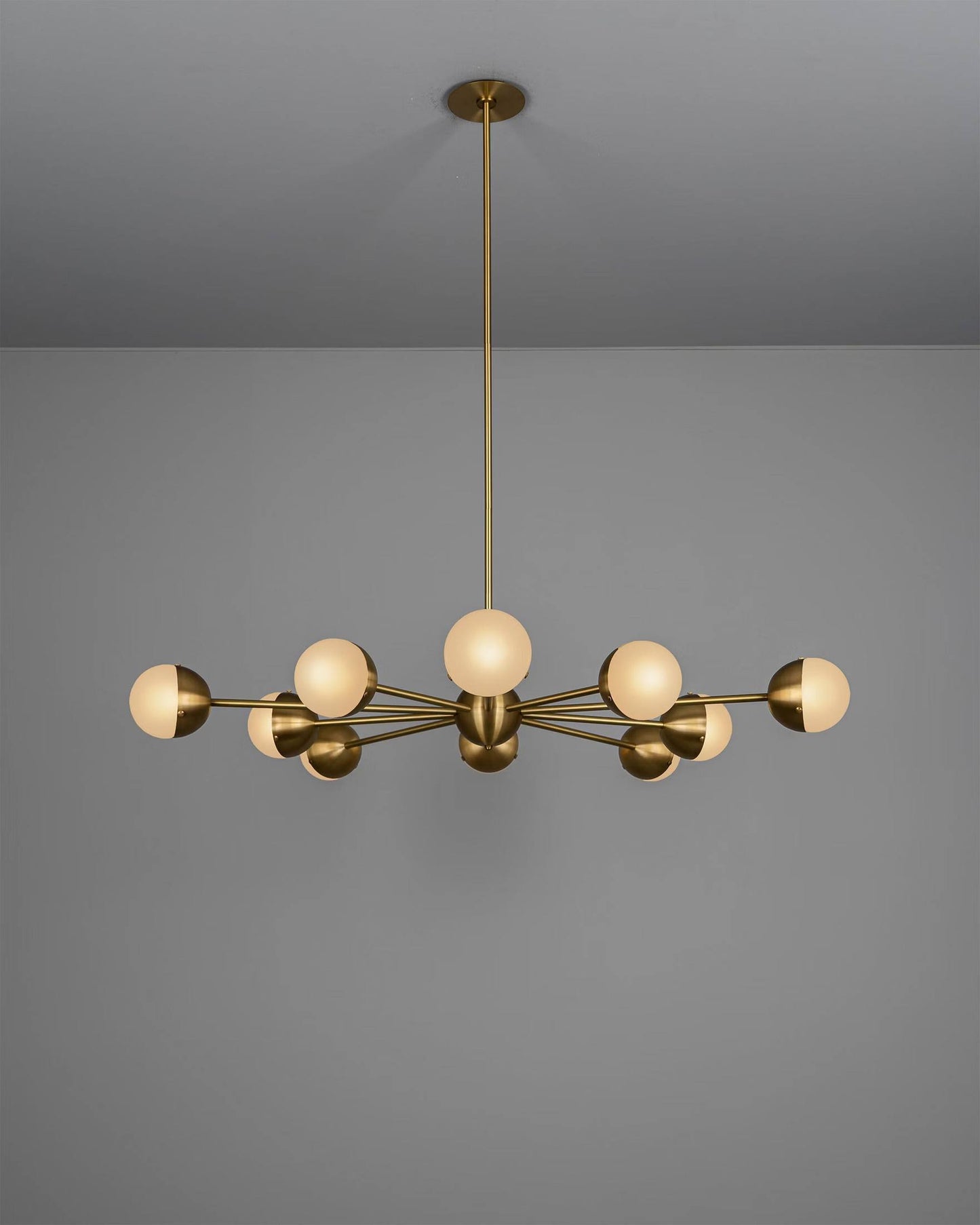 Molecule Spark Round 10 chandelier illuminated, showcasing its warm glow and artisanal details.