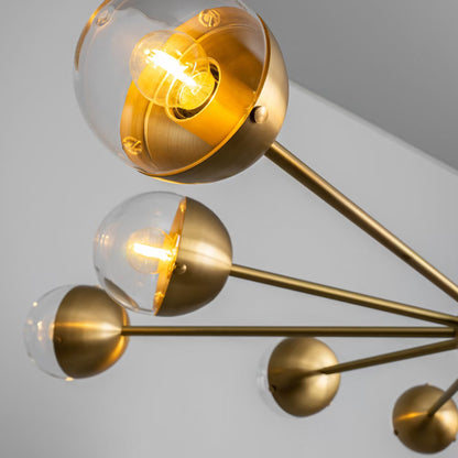 Close-up of handblown transparent globe emitting warm light, accented by burnished brass.