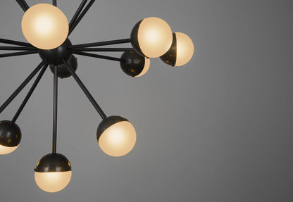 Black chandelier with glowing frosted glass globes, featuring sleek rods and a modern design.