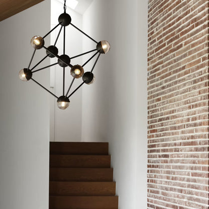 Geometric black chandelier with transparent globes, beautifully lighting a staircase.