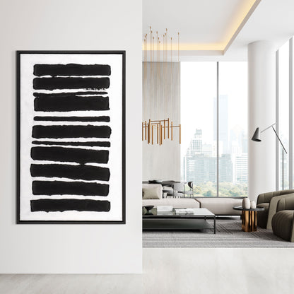 Framed black and white abstract painting displayed in a modern living room.