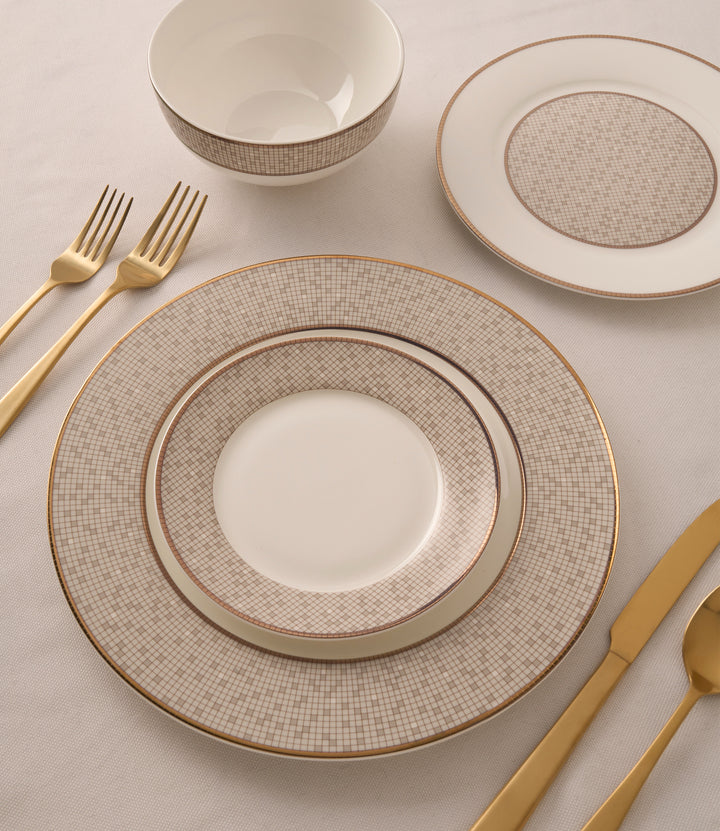 Mossaic Bone China dinnerware set displayed on a table with golden cutlery, highlighting the mosaic pattern and antique gold accents.