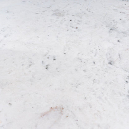 Close-up of the white marble tabletop with its light veining details.