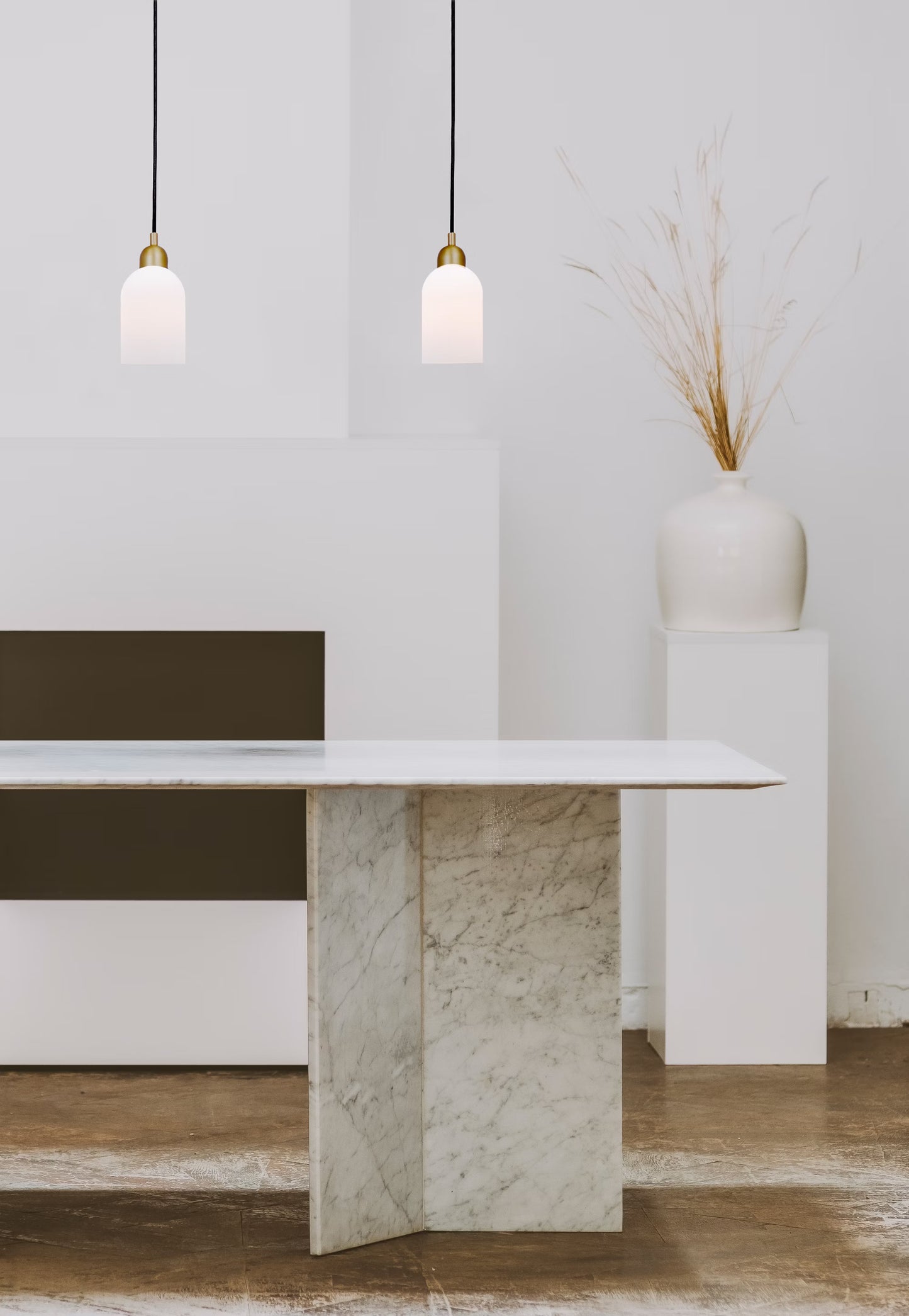 Two Odyssey Pendant Lights in brass illuminating a minimalist white space with a marble table.