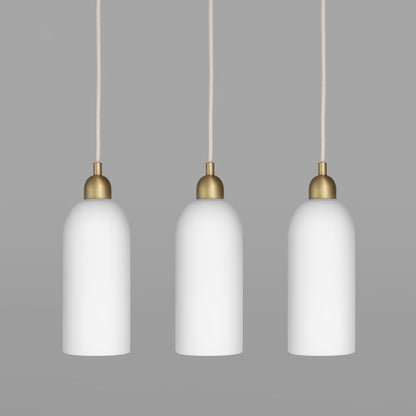 Three Odyssey Pendant Lights in white glass and brass finish in a row against a gray background.