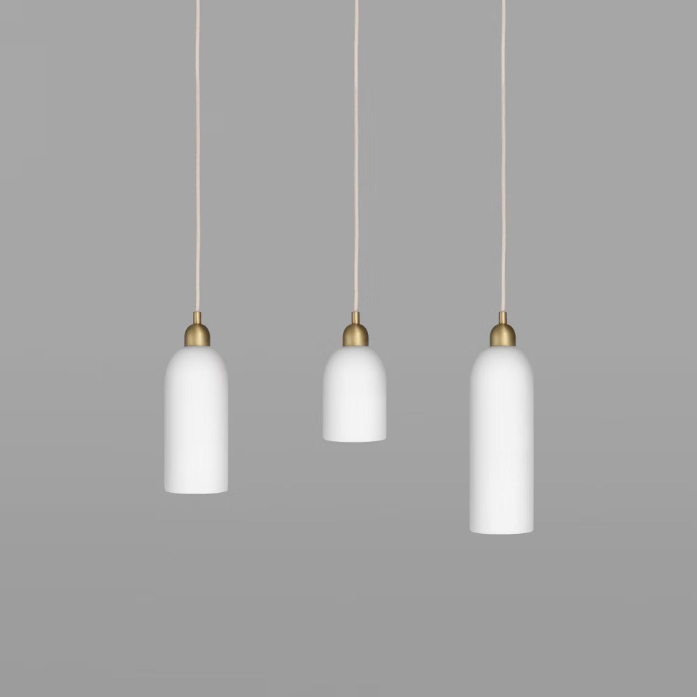 Set of three Odyssey Pendant Lights in various sizes with brass finish and soft white glow.