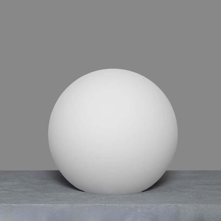 Single opal matte globe on a textured surface, minimalist elegance.