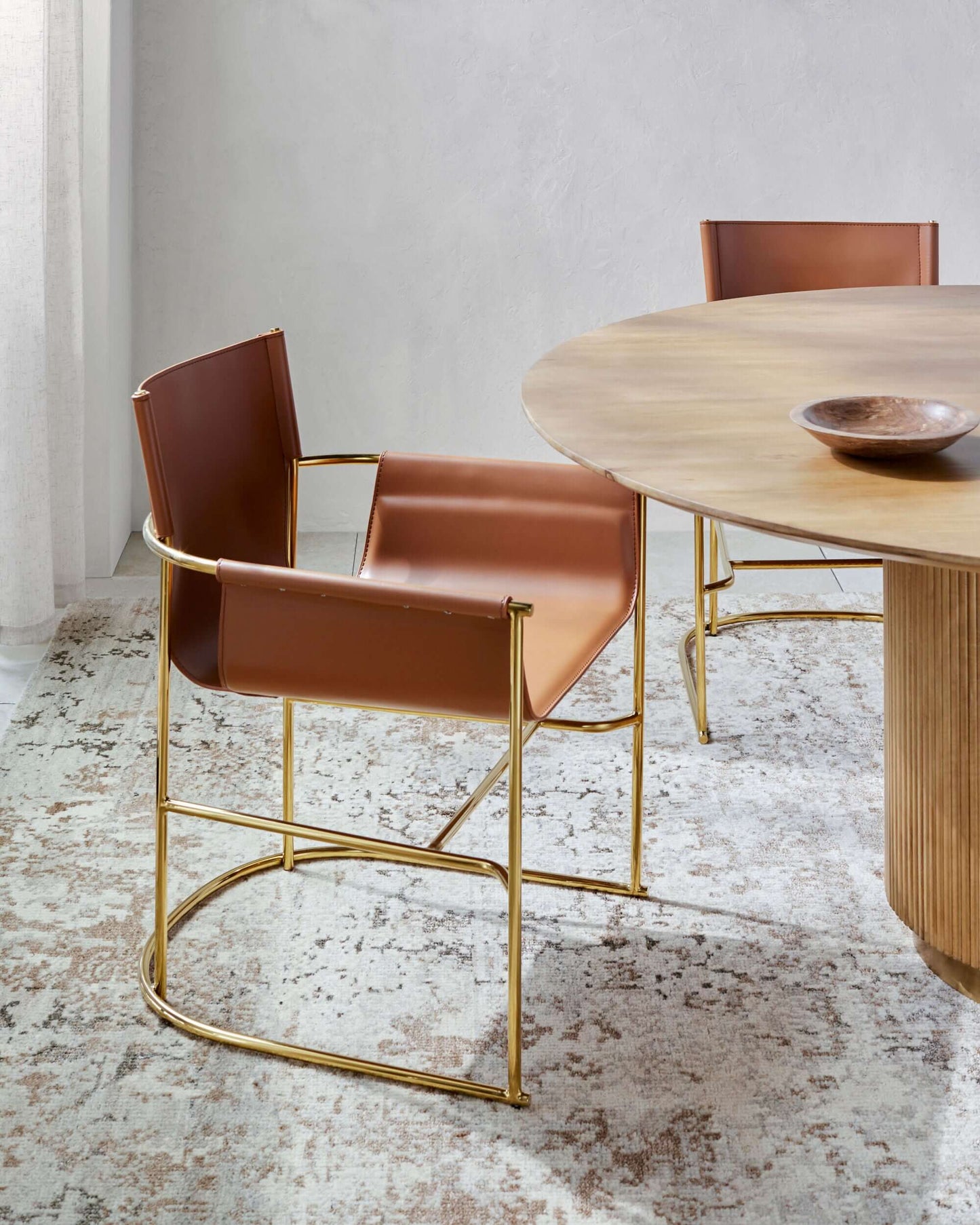 Surya Kara dining chair featured in a contemporary dining room, paired with a round dining table.