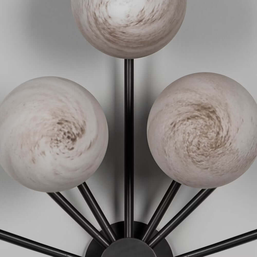 Close-up of Orion Oval Chandelier globes in marble matte finish with sleek black gunmetal frame.