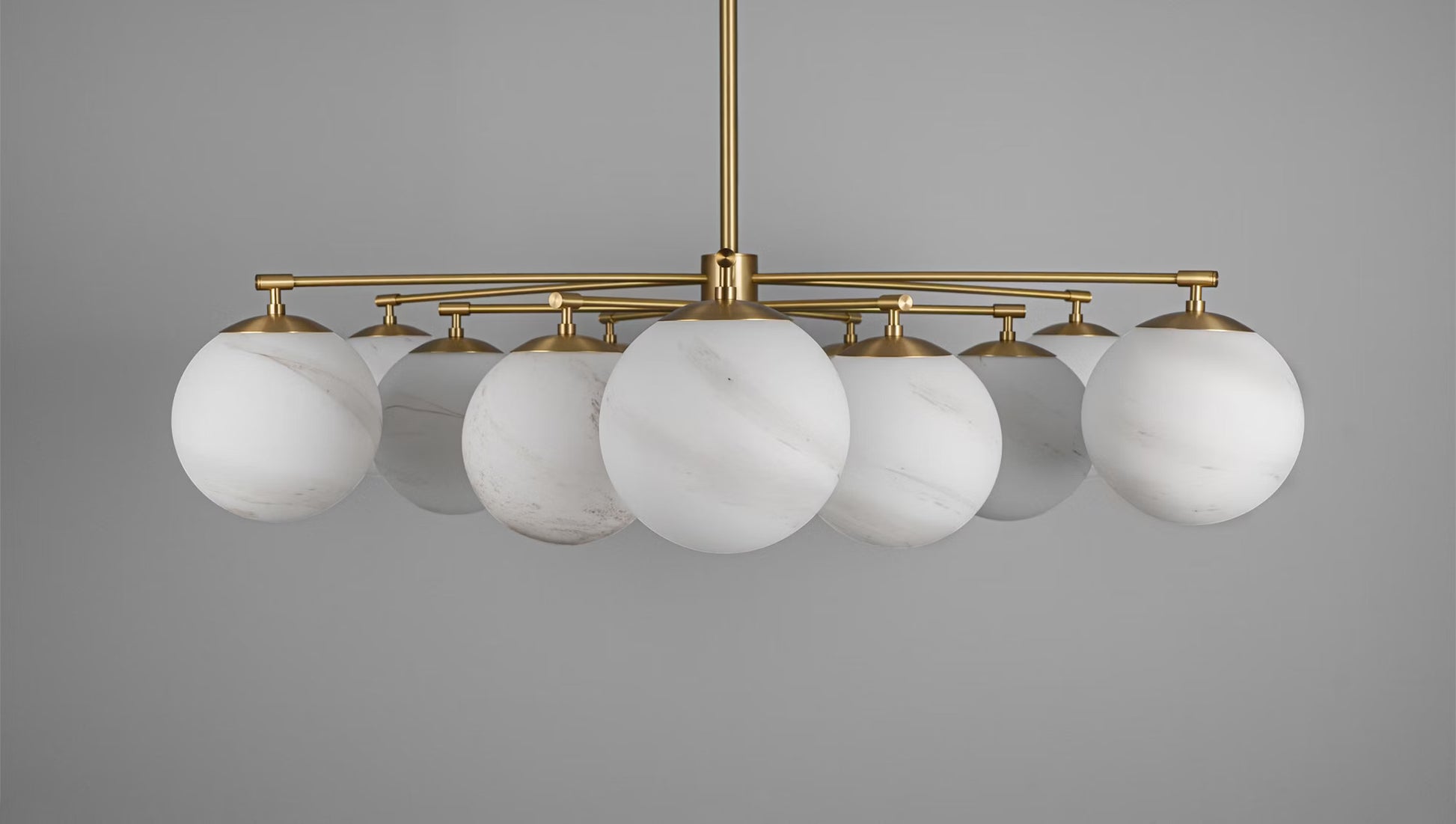 Full view of Orion Round Chandelier with Marble Matte Glass Globes and Brass Details.