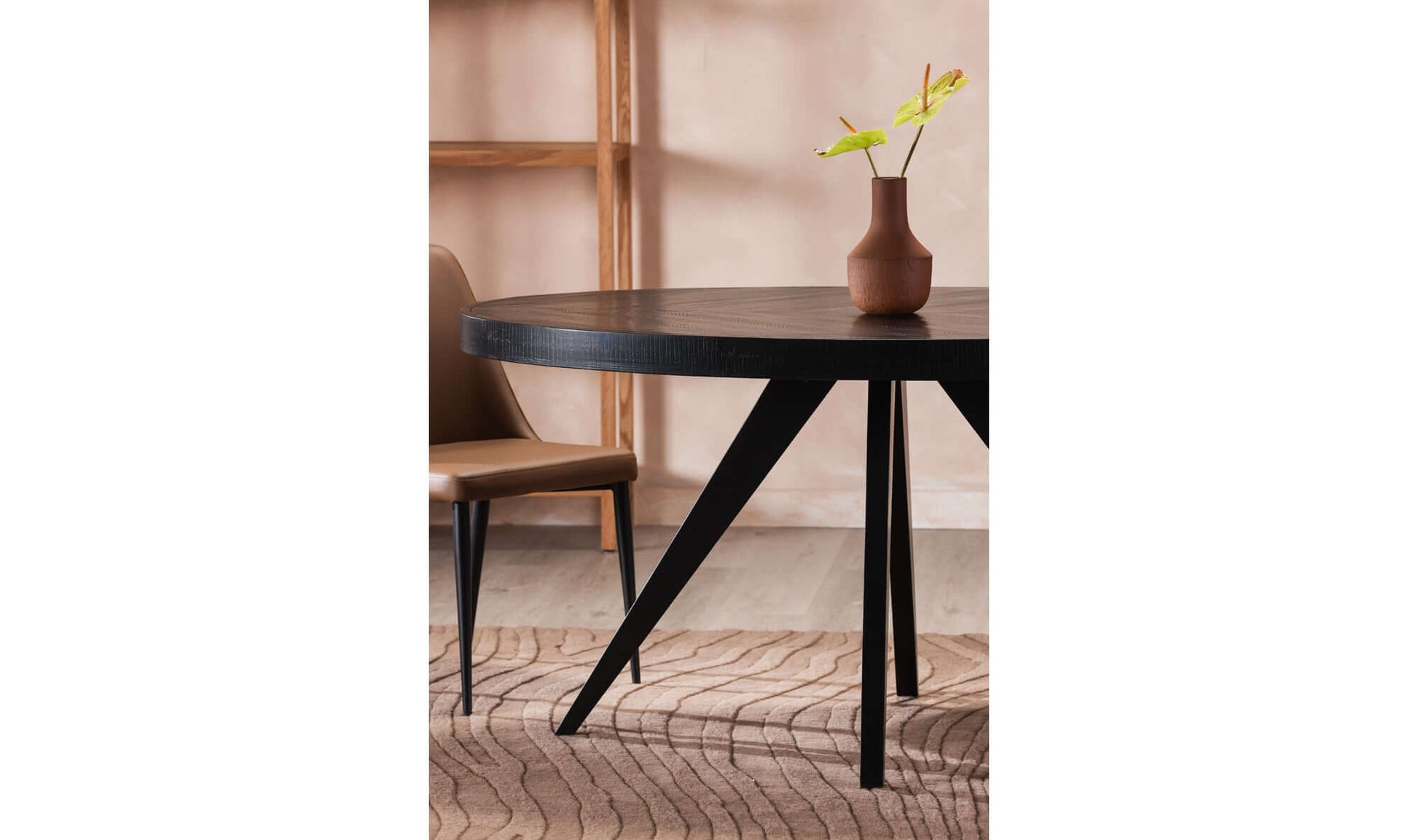 Parq Black Oval Dining Table in a modern dining room setup with a vase and chair.