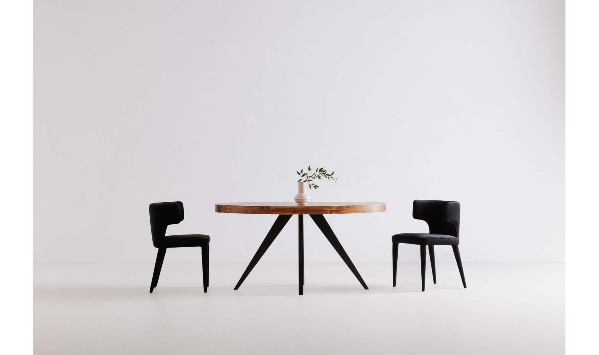 Minimalistic setting with Parq Oval Rustic Dining Table and black dining chairs.