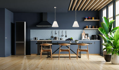 polished nickel pendants above navy modern kitchen.