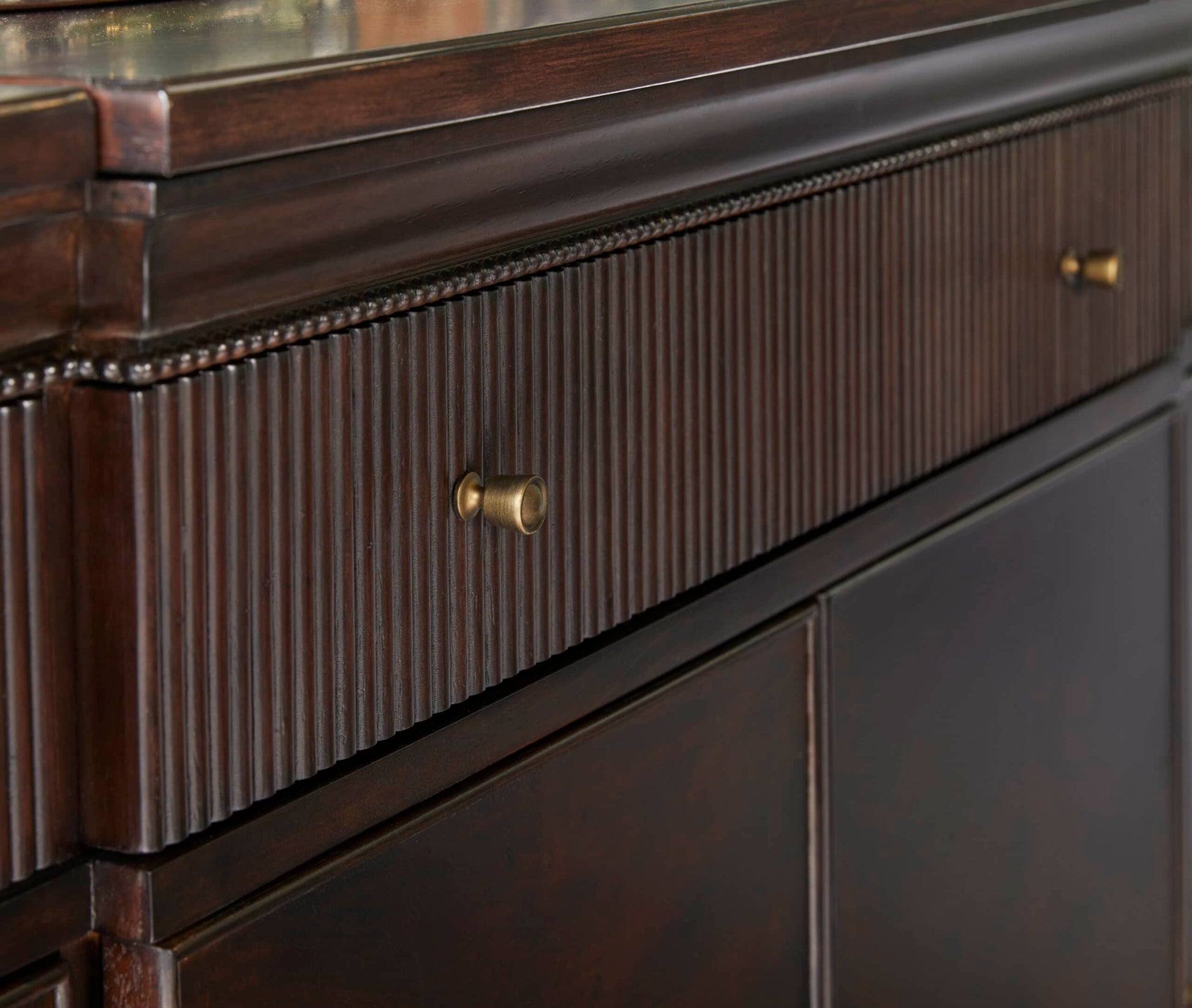 Detailed view of the drawer fronts on the Revival Credenza, showcasing the reeded design and brass knobs.