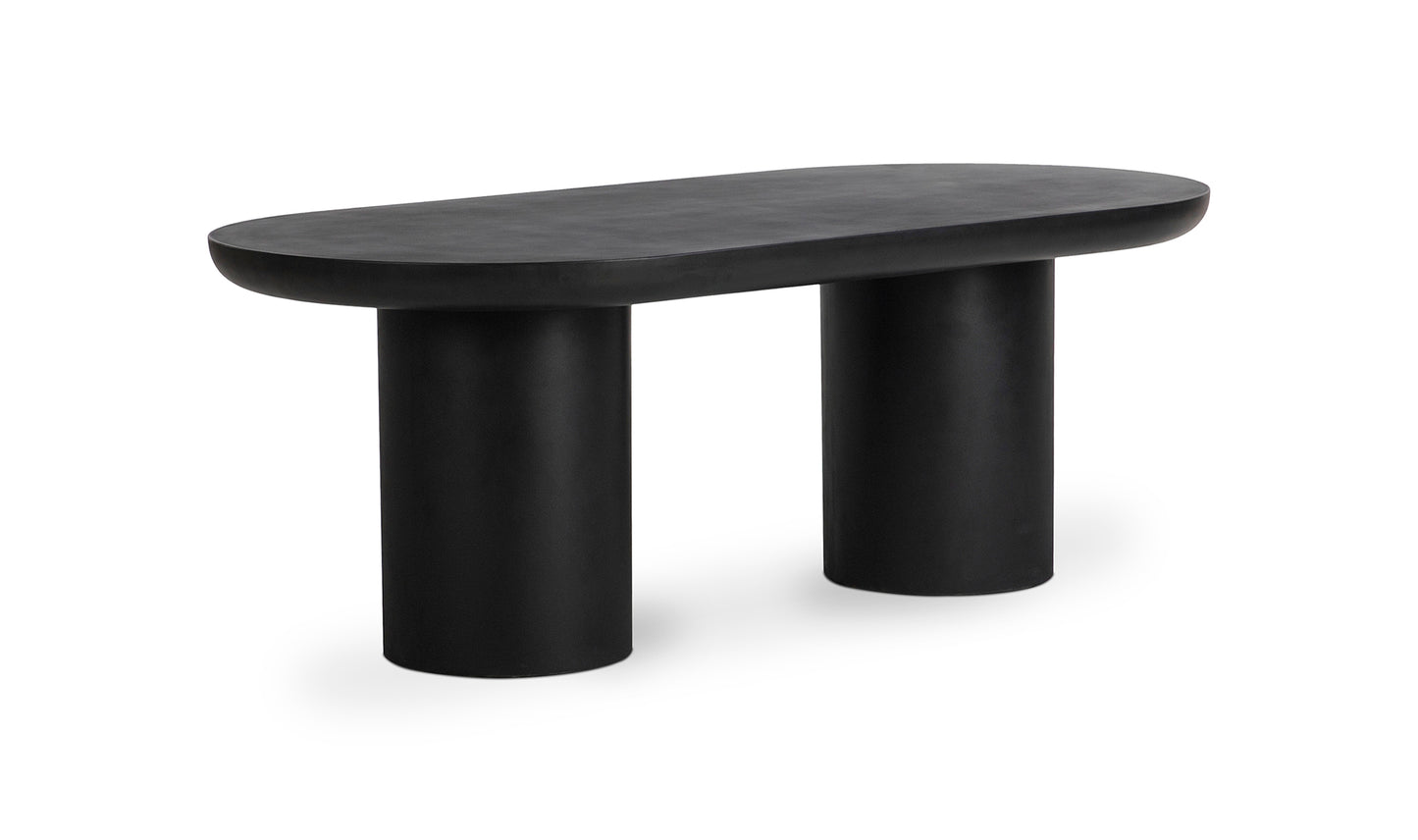 Angled view of the Rocca black concrete dining table in a modern setting, with its robust concrete top and iron frame.