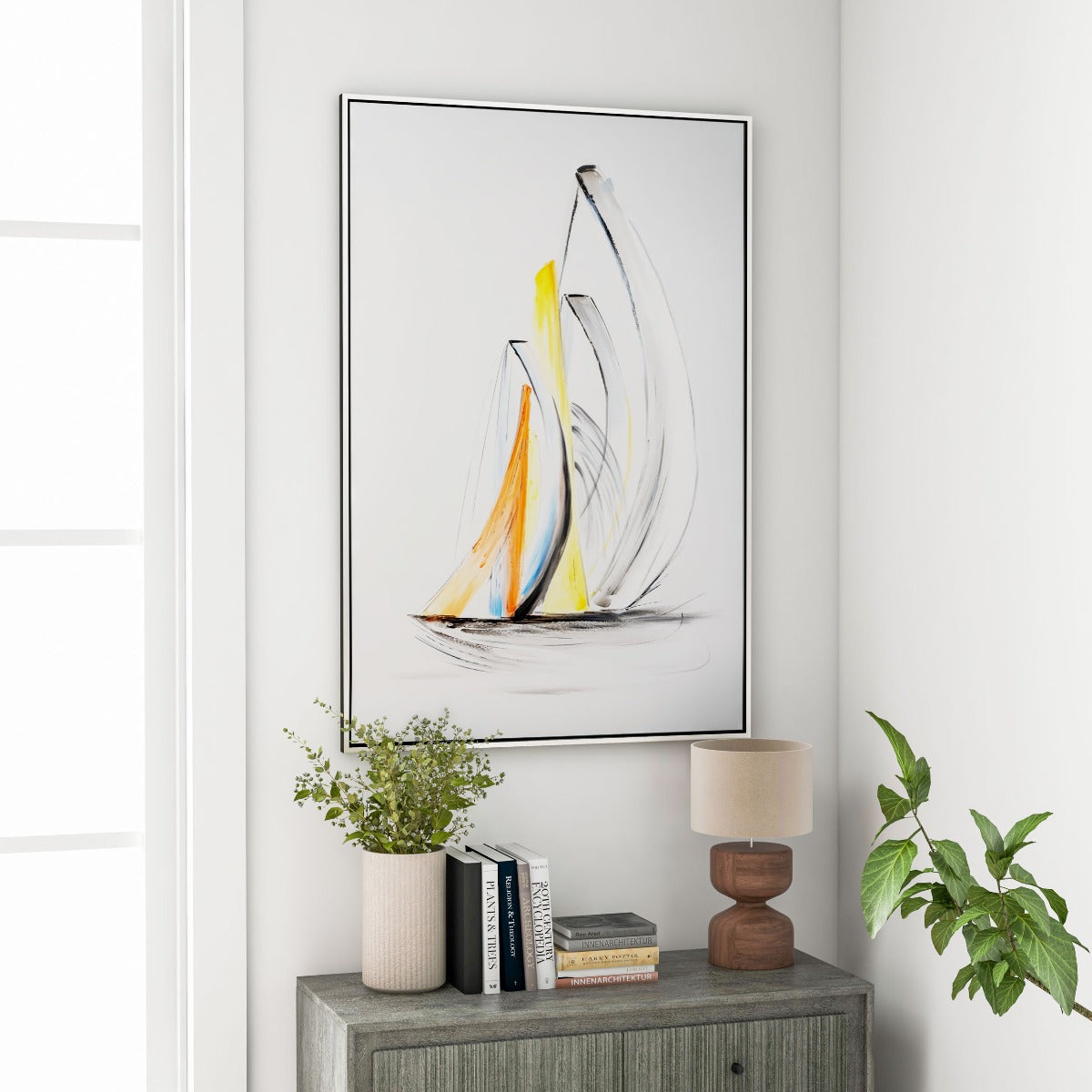 coastal artwork displayed above a stylish wooden console with books and plants.