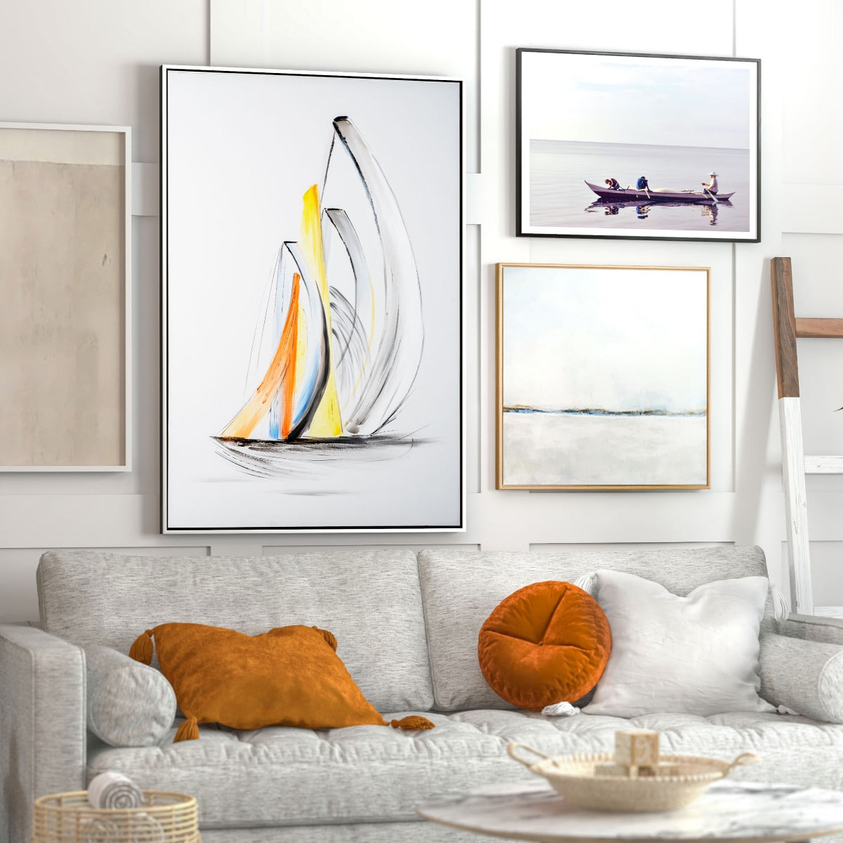 Framed canvas wall art hanging above a cozy grey sofa with orange pillows.