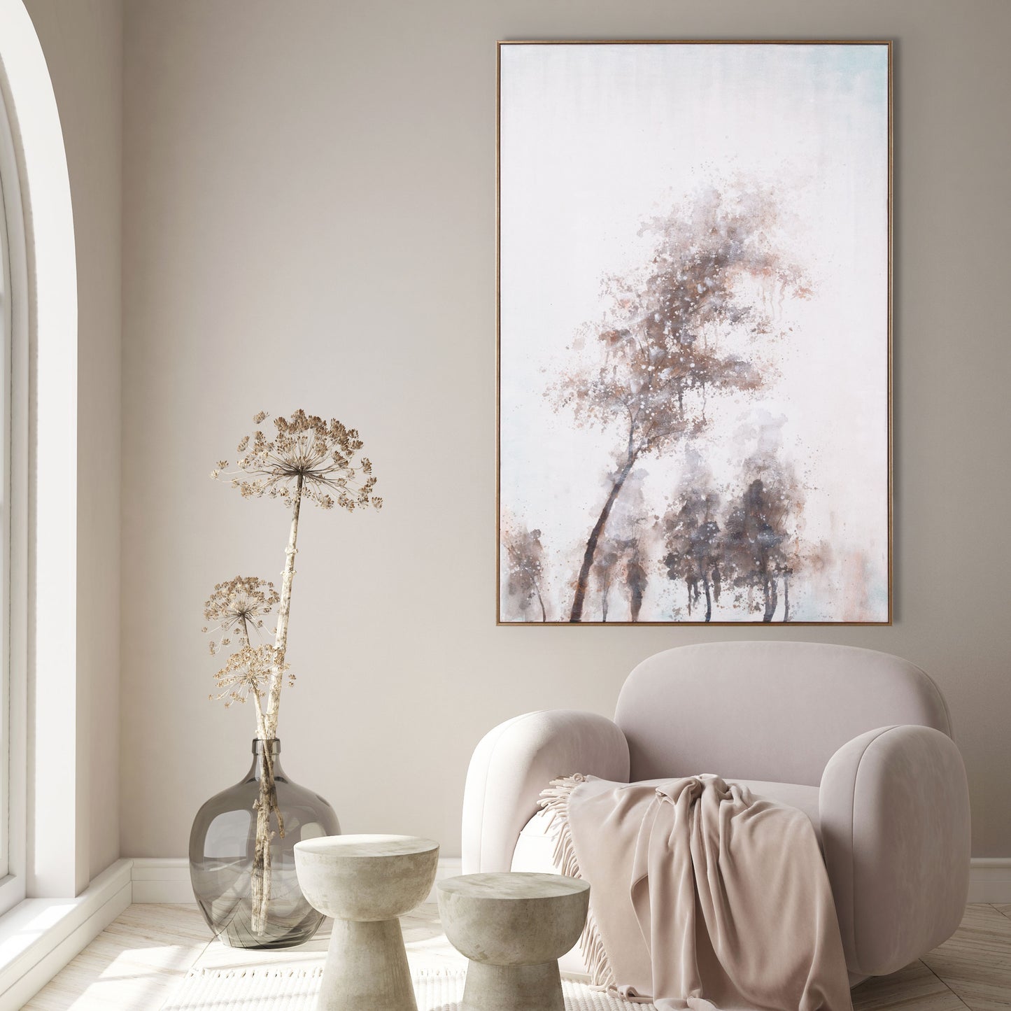 Neutral-toned living space with tree painting complementing a cozy beige armchair.