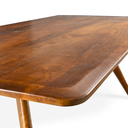 Close-up of Sterling 78" dining table corner showcasing smooth walnut brown finish and rounded edges.