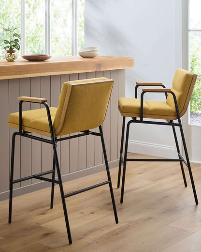  Stylish setting featuring two Thomas Bar Stools by Surya at a wooden counter, emphasizing the bold yellow seats and industrial design.