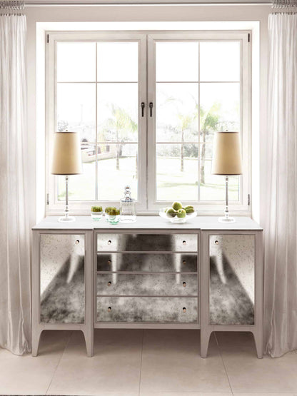 Transitional grey buffet with antique mirror front and storage, set in a well-lit dining room.