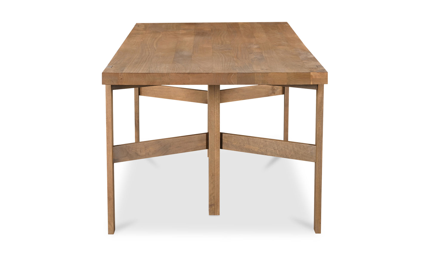 Profile view of the Workshop modern wooden dining table showcasing its rectangular wooden surface and sturdy cross-brace leg design.