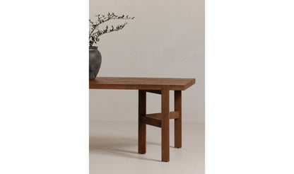 A close-up side view of the Workshop modern wooden dining table's corner, showing its clean-lined mango wood design and rustic brown finish,