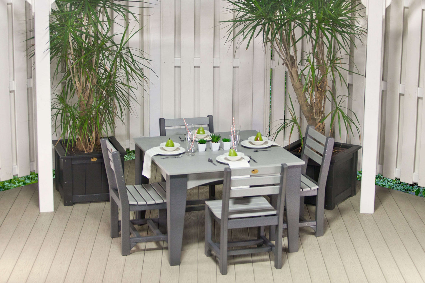 Celeste Square Poly Wood Outdoor Dining Set, 5-piece with gray table and chairs, elegantly set up on a patio surrounded by tall green potted plants.