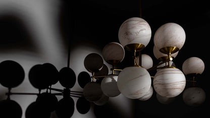 Zodiac Chandelier with marble matte globes and burnished brass frame in dramatic lighting.