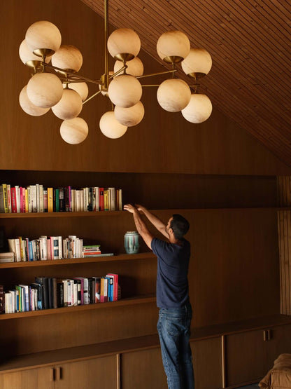 Zodiac Chandelier installed in a wood-paneled room.